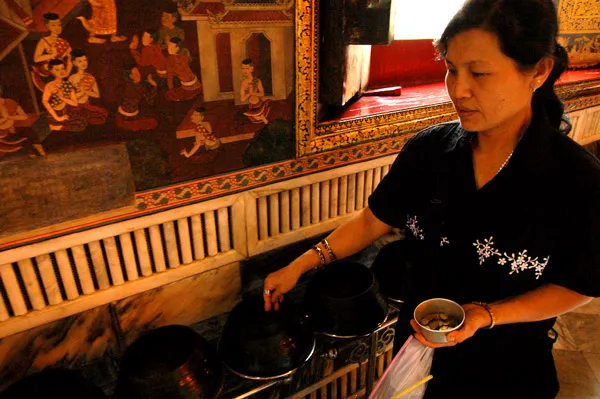 Tajlandia | Drobne monety często składane są w ofierze u wrót buddyjskich świątyń Tajlandia | Drobne monety często składane są w ofierze u wrót buddyjskich świątyń